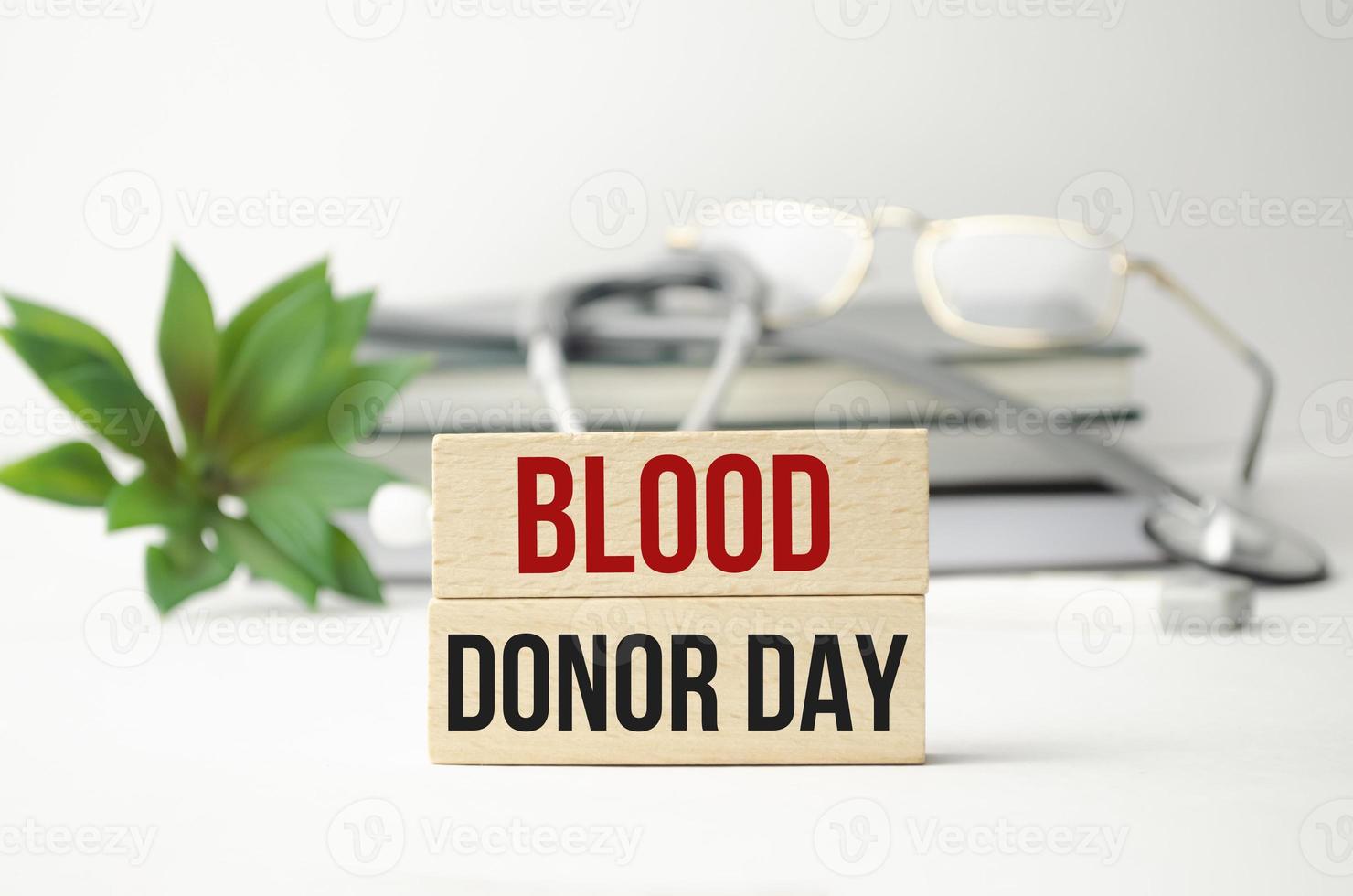 blood donor day words on notebook and stethoscope on wooden cubes photo