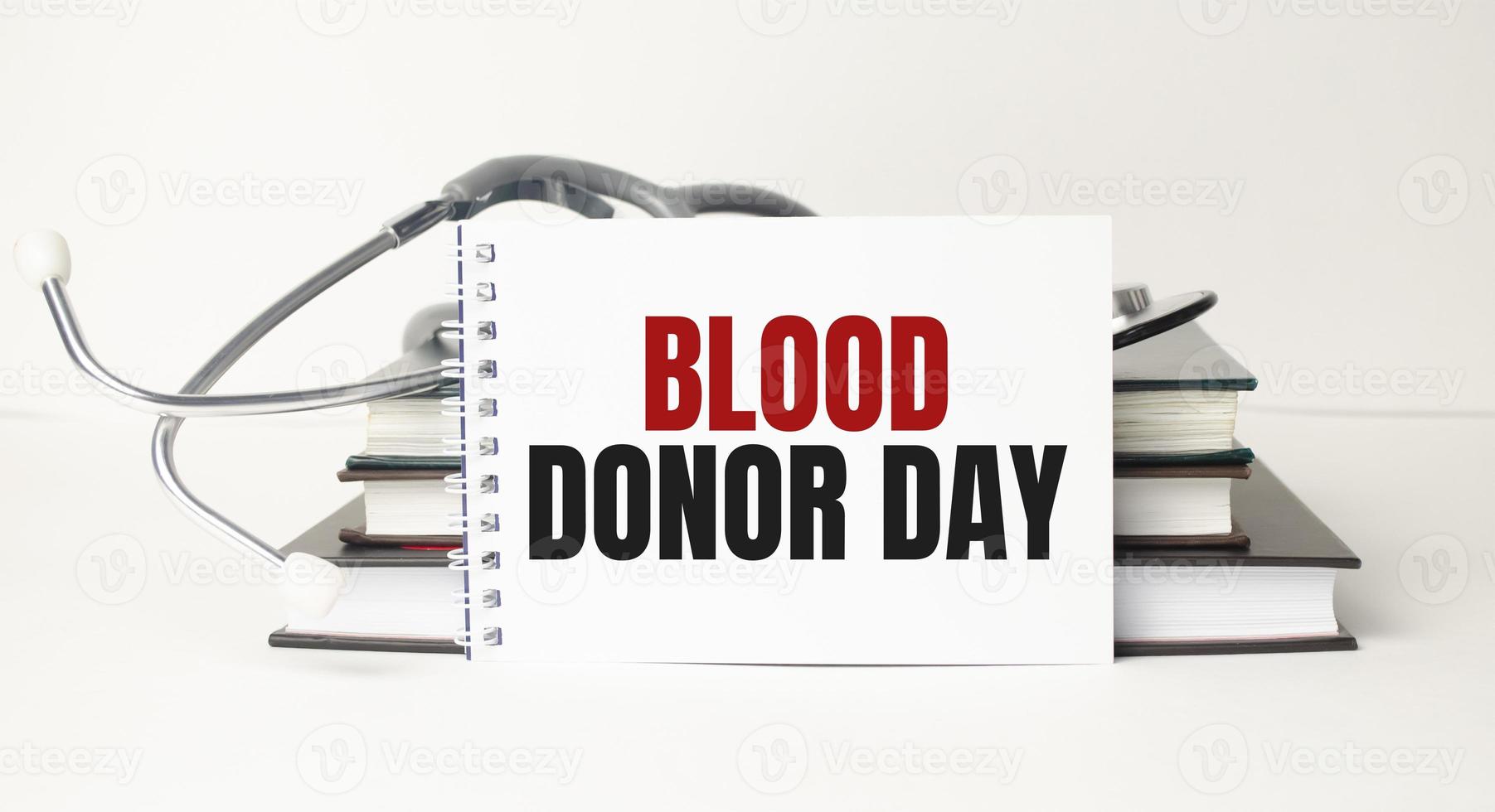 blood donor day words on notebook and stethoscope on wooden background photo