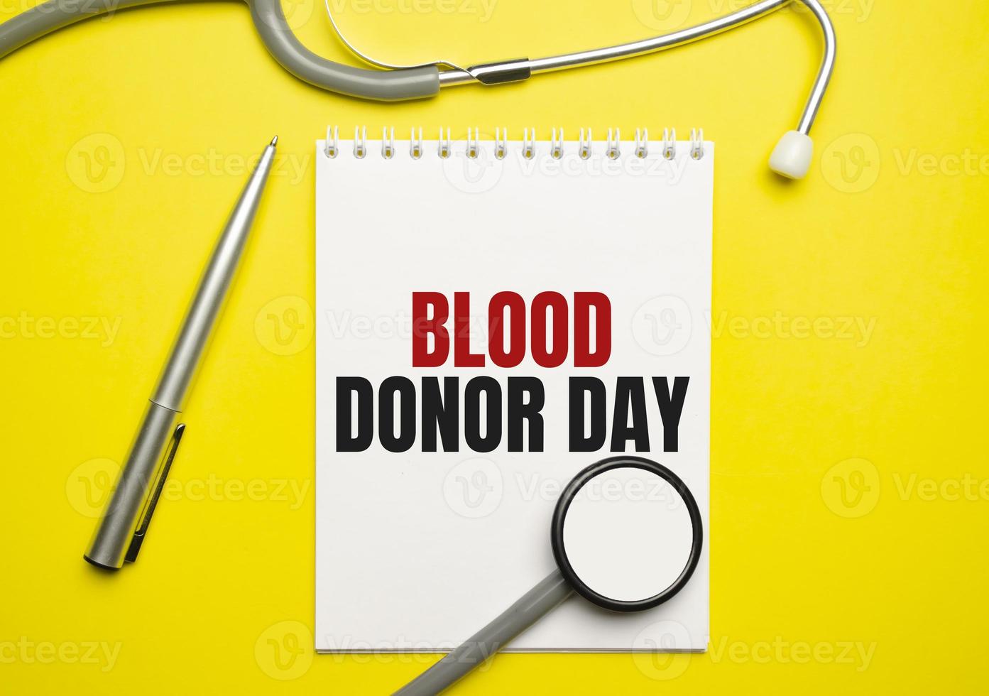 blood donor day words on notebook and stethoscope on yellow background photo