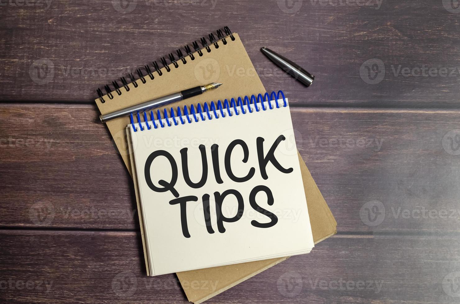 QUICK TIPS words on notebook on wooden background photo