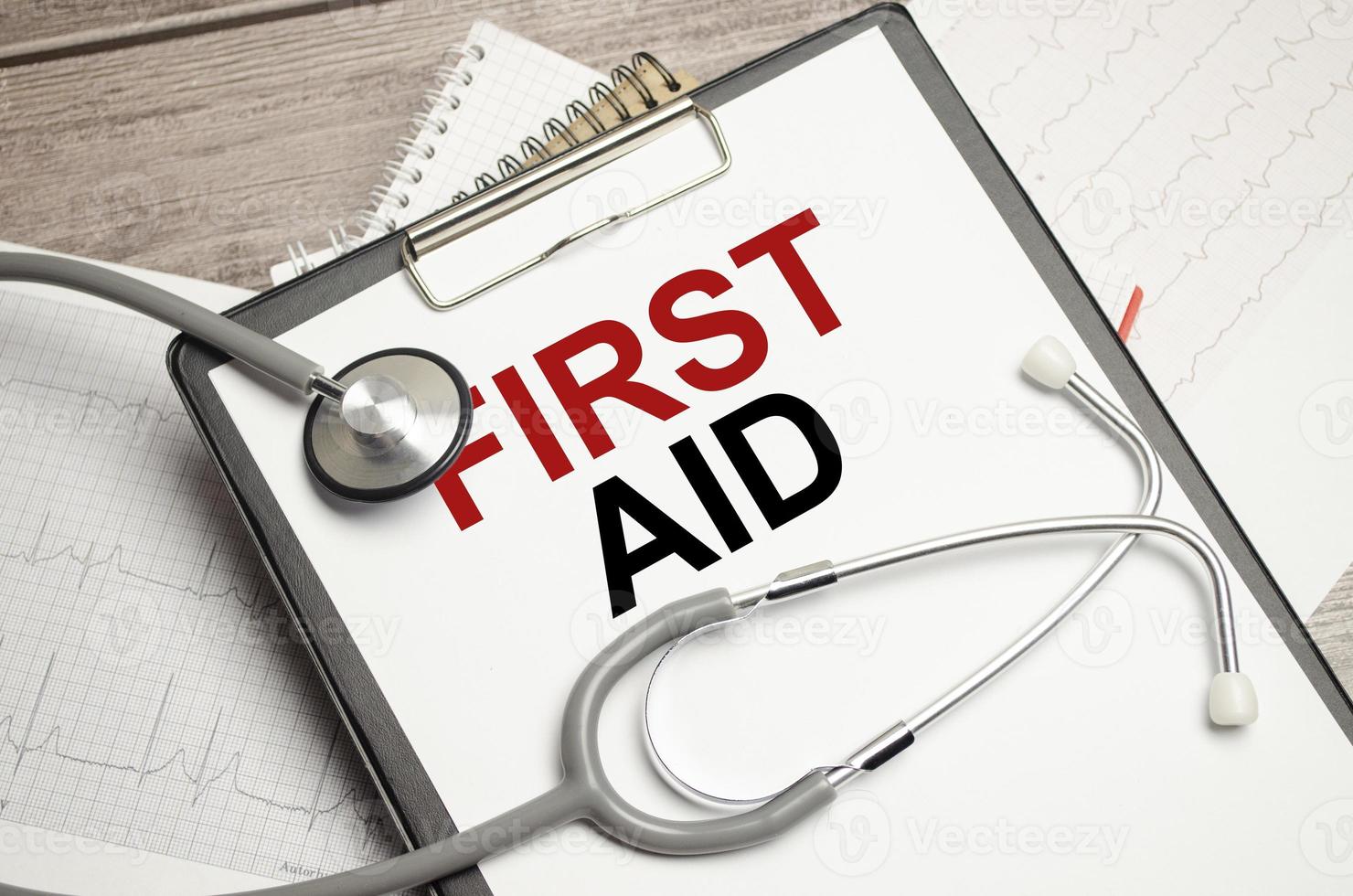 first aid words on paper plate with stethoscope and charts photo