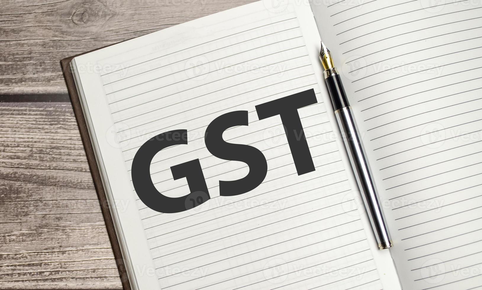 GST text on notepad with pen, business concept photo