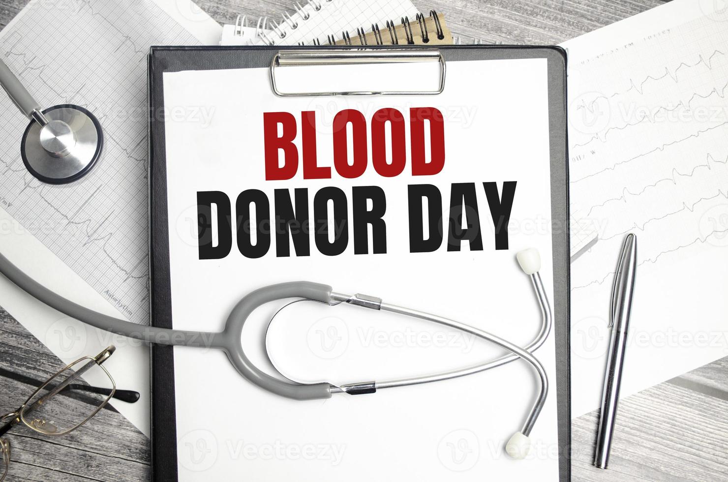blood donor day words on notebook and stethoscope on wooden background photo