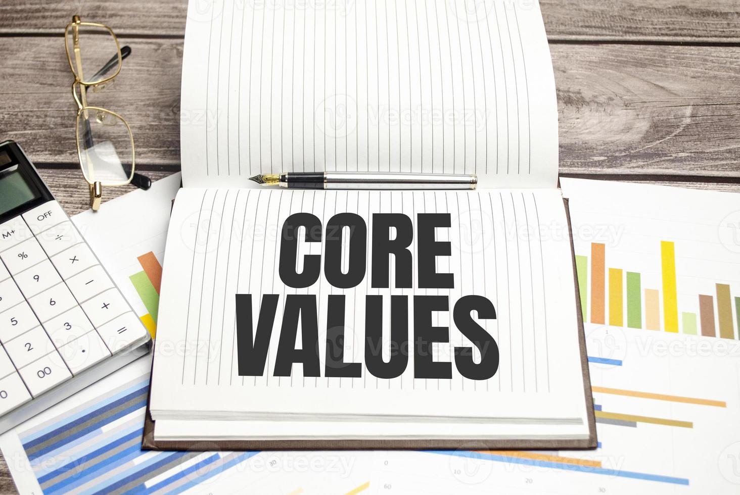 text core values on brown diary with calculator, glasses on wooden background photo