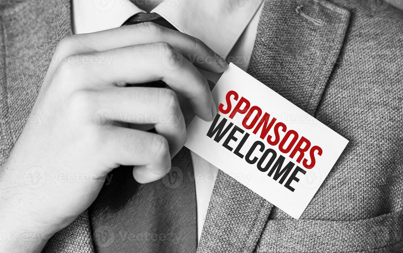 Businessman putting a card with text Sponsors Welcome in the pocket photo