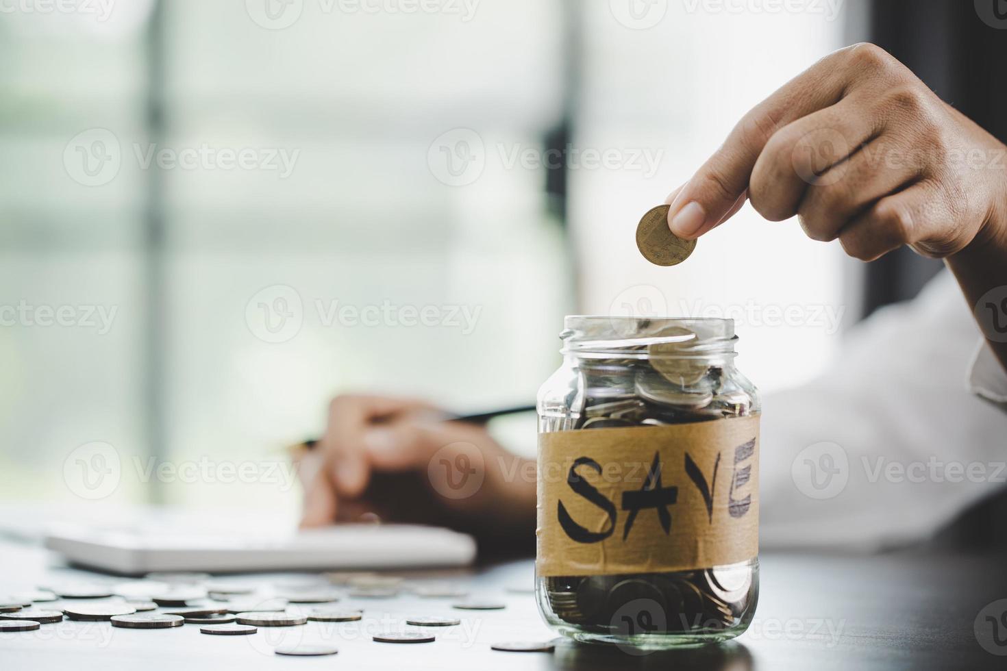 mujer mano poniendo dinero en tarro foto