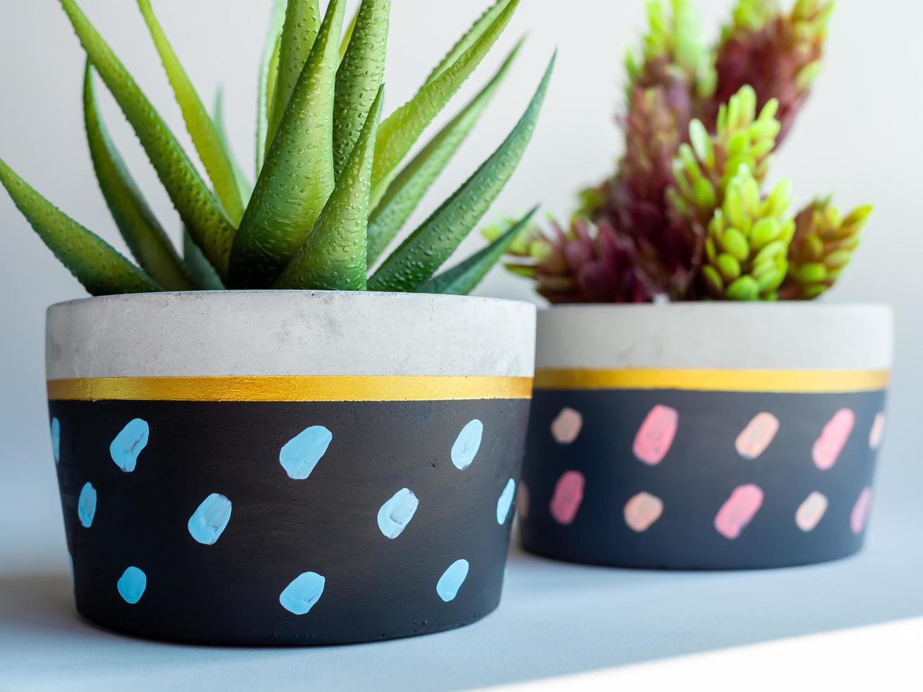 Colorful round geometric planters. Painted concrete pots for home decoration photo