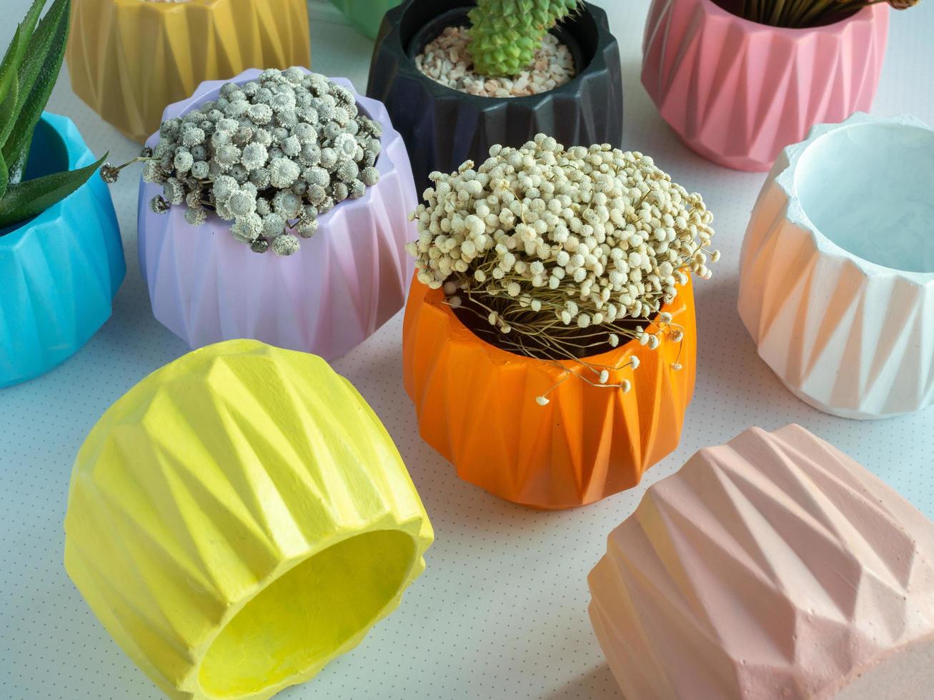 Colorful geometric planters. Painted concrete pots for home decoration photo