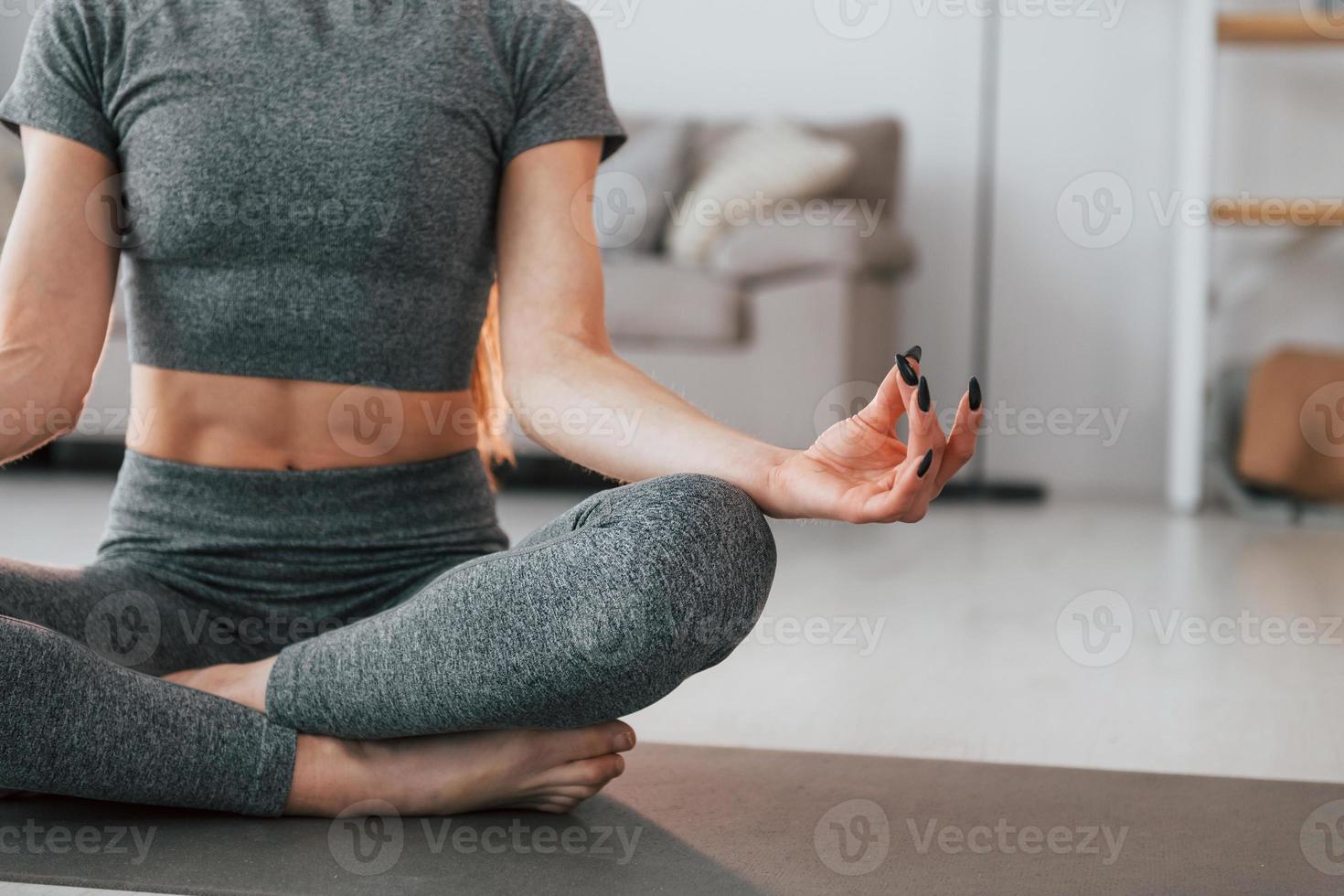 habitación doméstica. mujer joven con cuerpo delgado y ropa de yoga está en casa foto