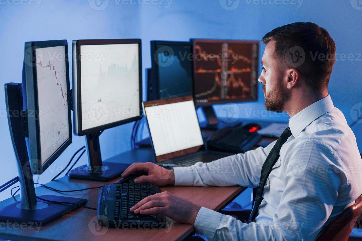 Many of the monitors. Stock trader working in the office with exchange technology photo