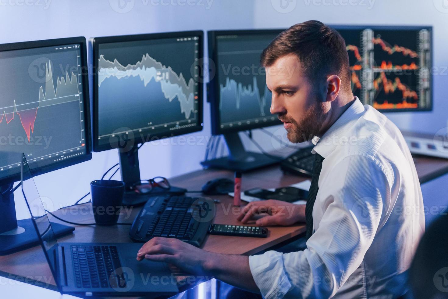 Focused on work. Stock trader is in the office with exchange technology photo