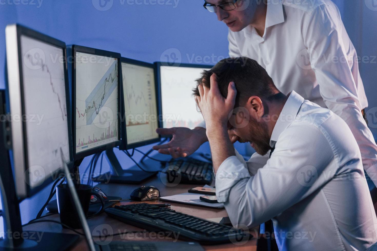 Bad luck, failure. Two stock traders working in the office with exchange technology photo