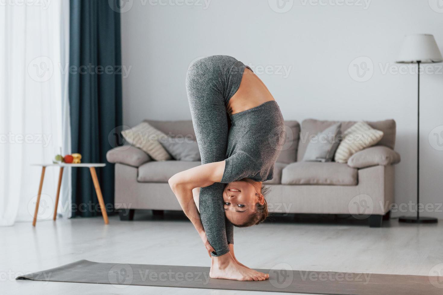 Healthy lifestyle. Young woman with slim body type and in yoga clothes is at home photo