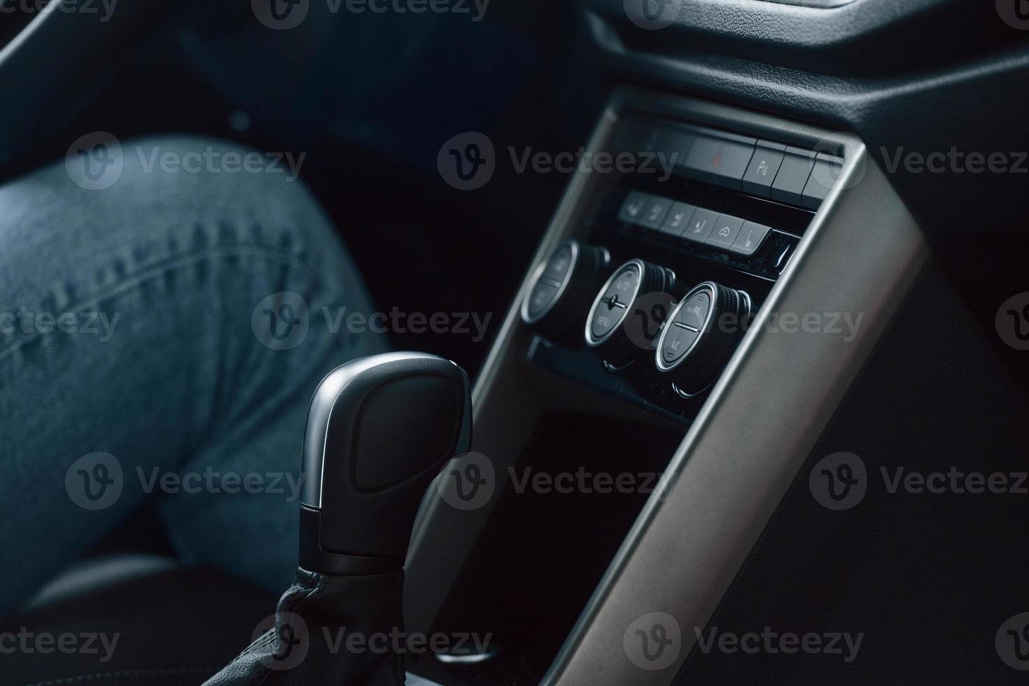 Sitting in the front seat. Woman is in autosalon at daytime photo