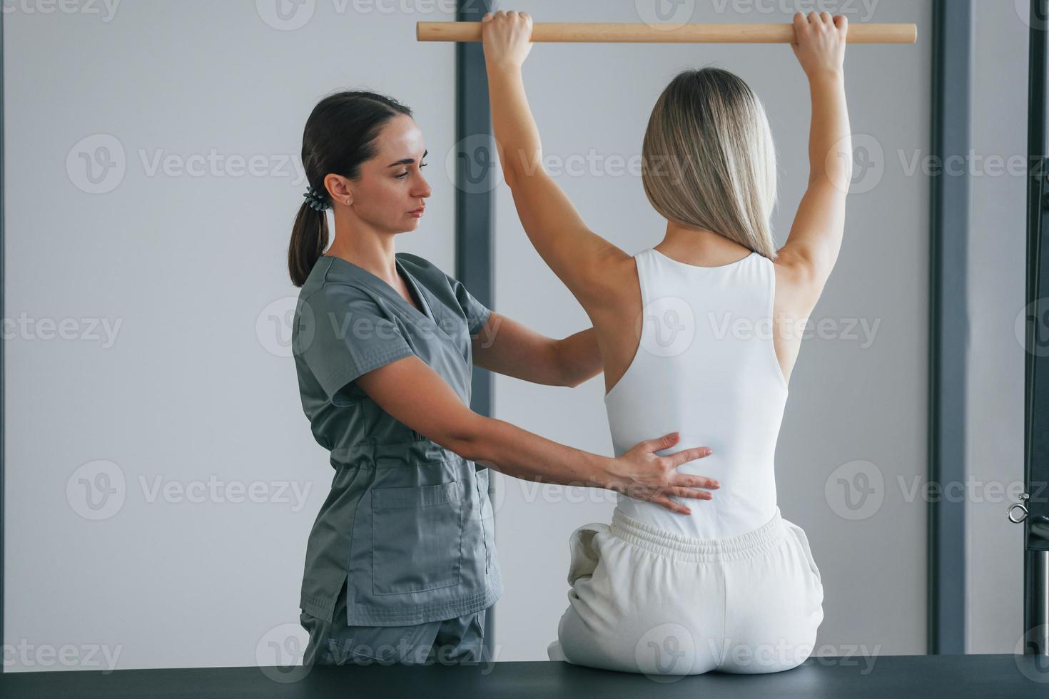 Spine exercises. Woman is in health center getting help by doctor photo