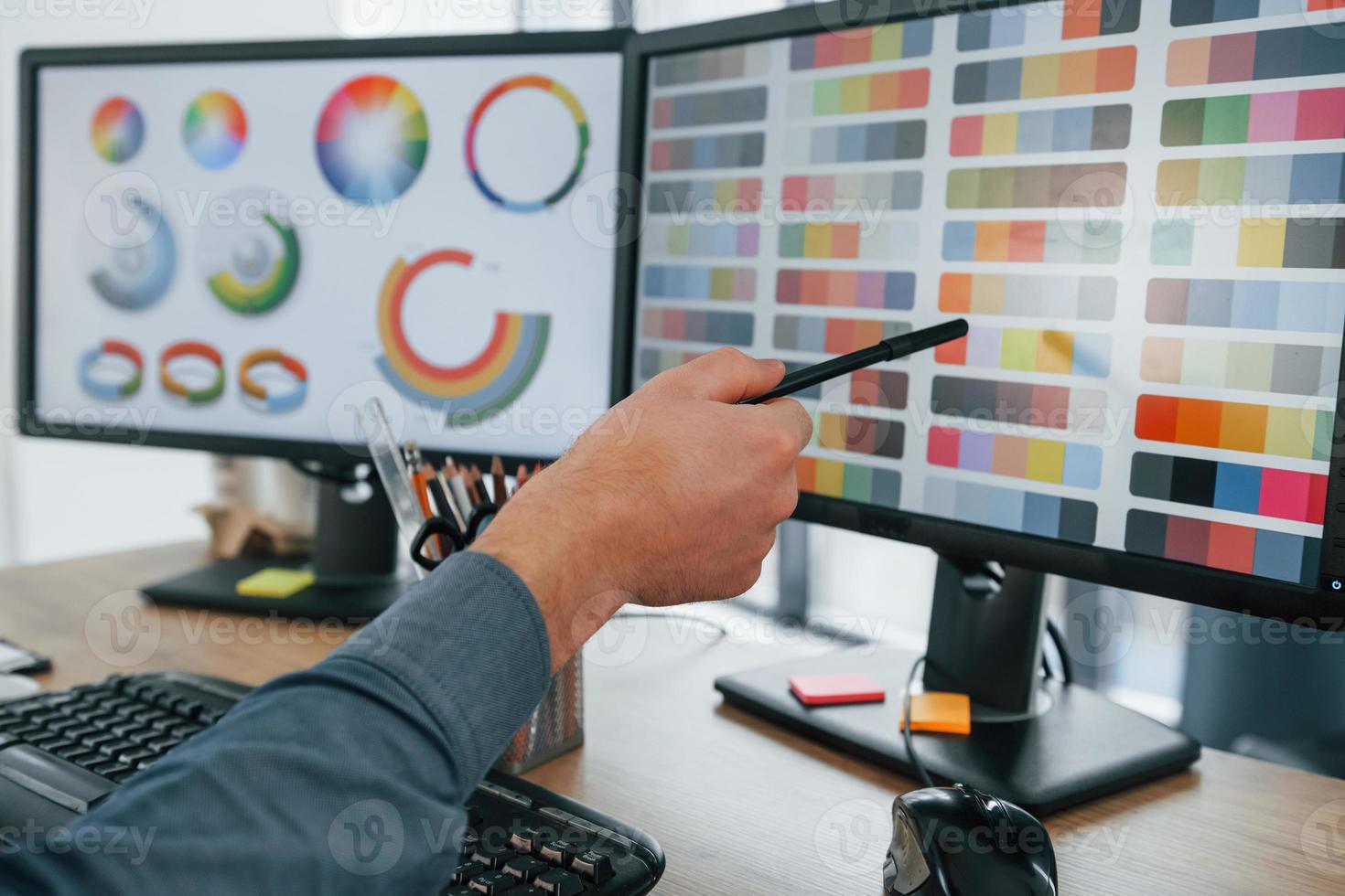 usando diferentes colores. diseñador masculino trabajando en la oficina usando pc foto