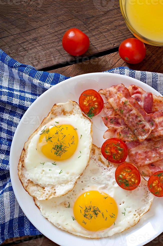 English breakfast - toast, egg, bacon and vegetables in a rustic style on wooden background photo