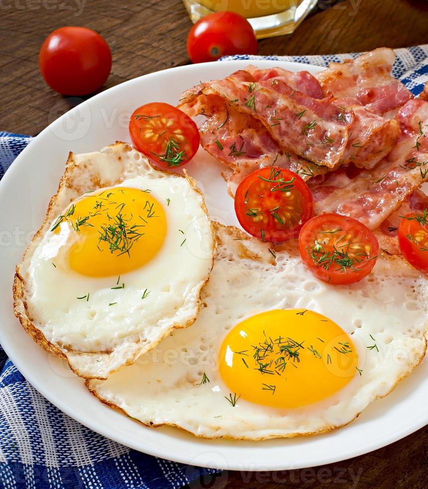 English breakfast - toast, egg, bacon and vegetables in a rustic style on wooden background photo