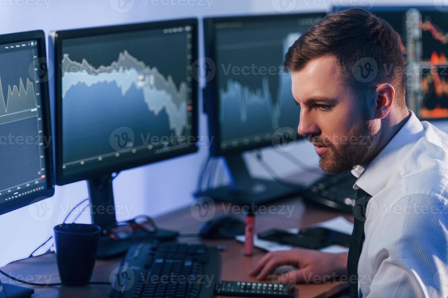 Focused on work. Stock trader is in the office with exchange technology photo