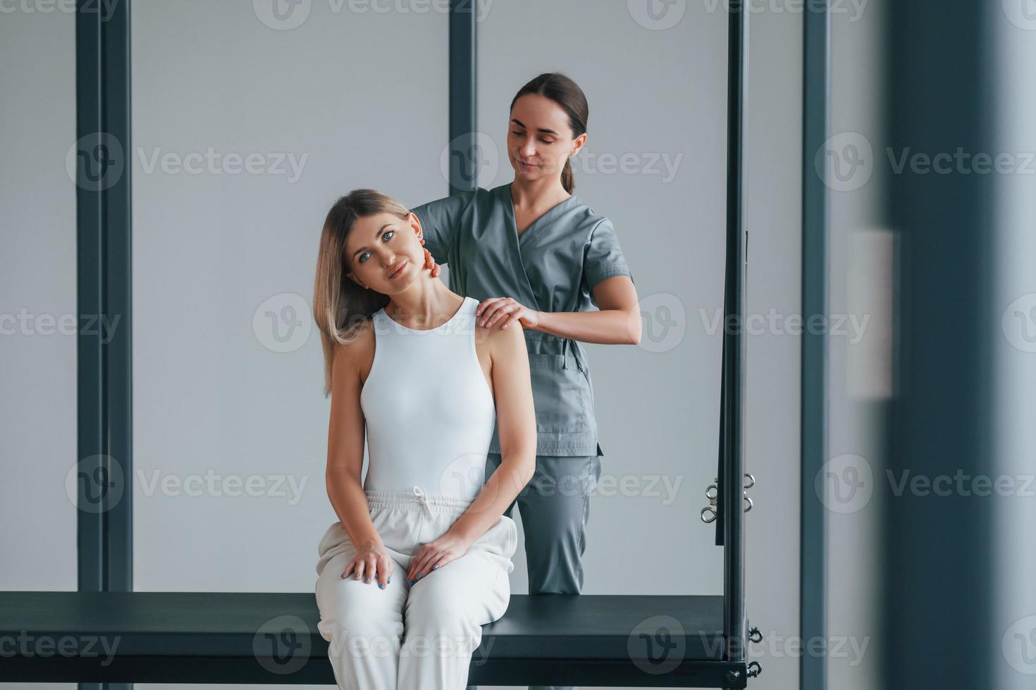 Neck exercises. Woman is in health center getting help by doctor photo
