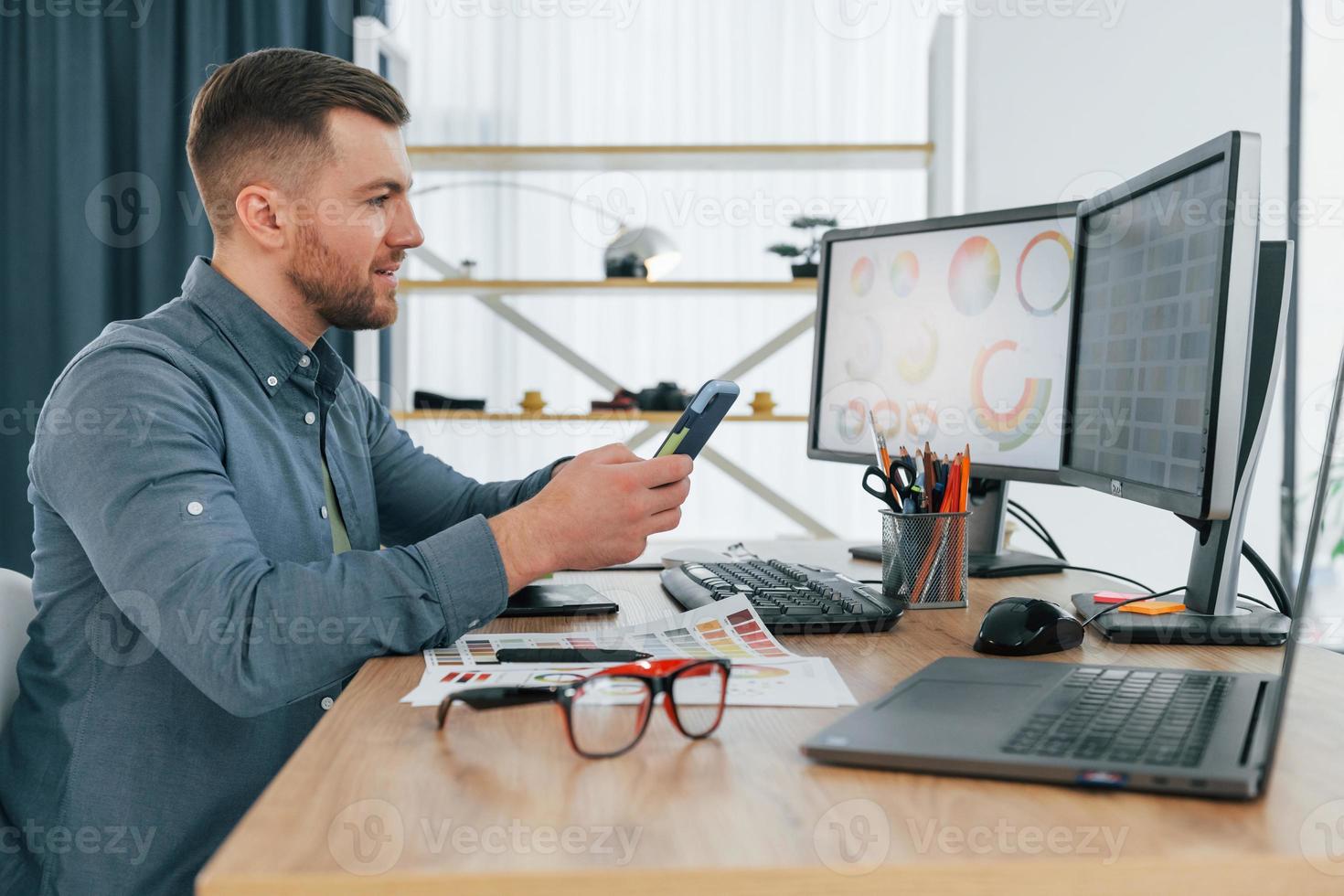 Using different colors. Male designer working in the office by using PC photo