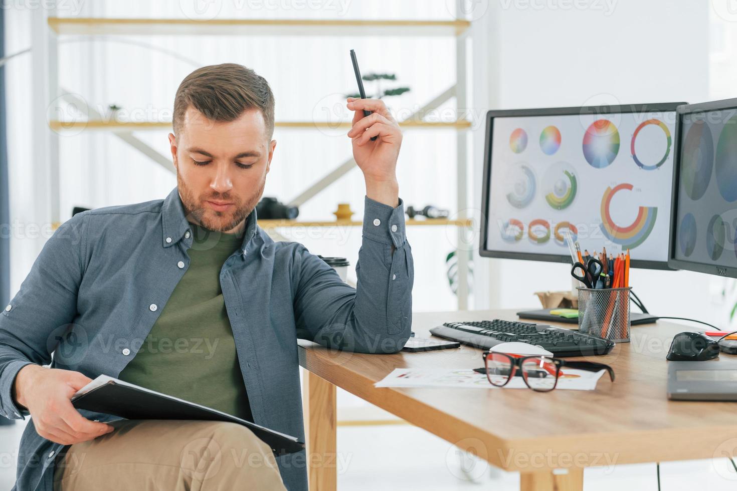 With tablet in hands. Male designer working in the office by using PC photo