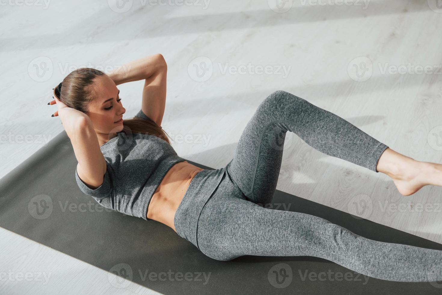 With yoga mat. Woman with sportive slim body type in underwear that is in  the studio 15303058 Stock Photo at Vecteezy