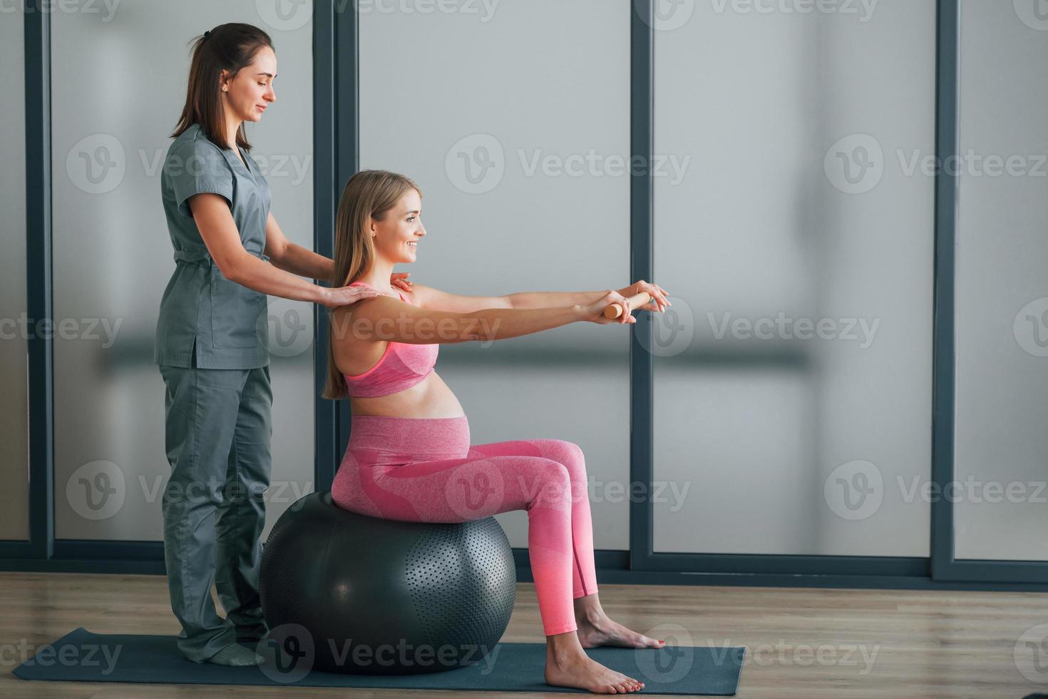 Pregnant woman is in health center getting help by doctor photo