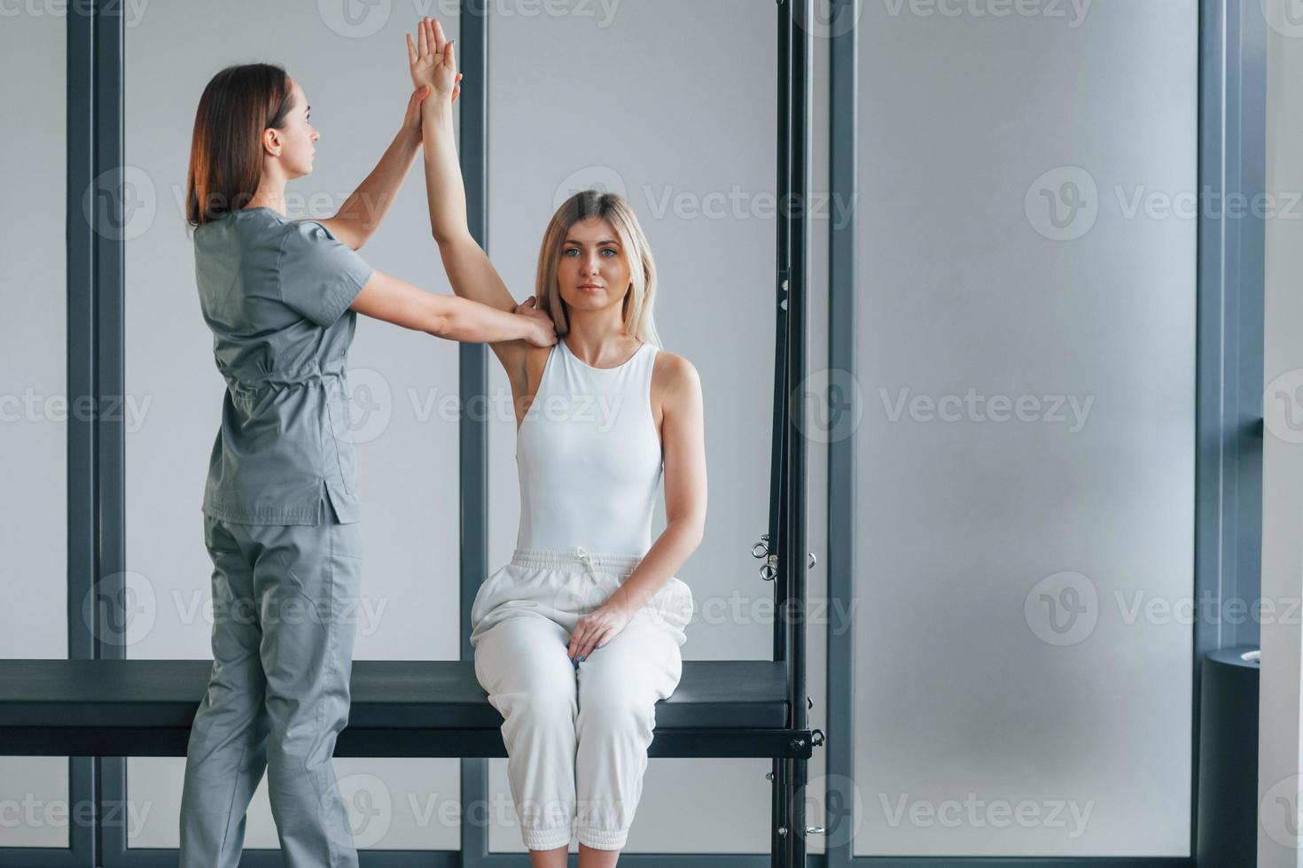 moviendo la mano. la mujer está en el centro de salud recibiendo ayuda del médico foto