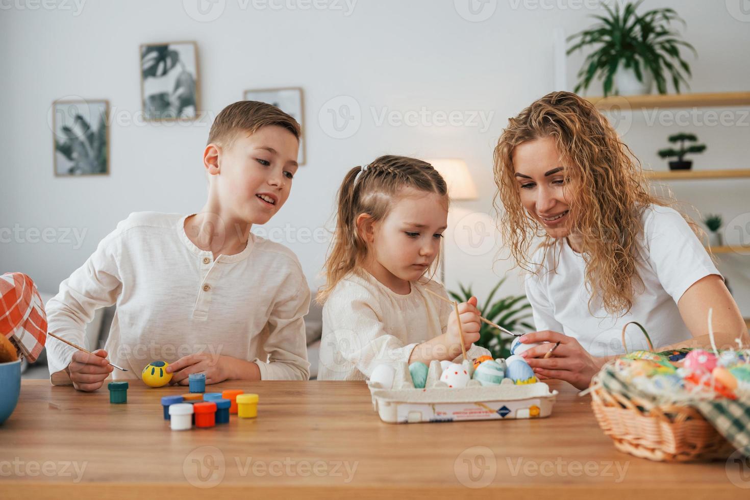 madre con su hijo y su hija. familia feliz celebrando juntos las vacaciones de pascua foto