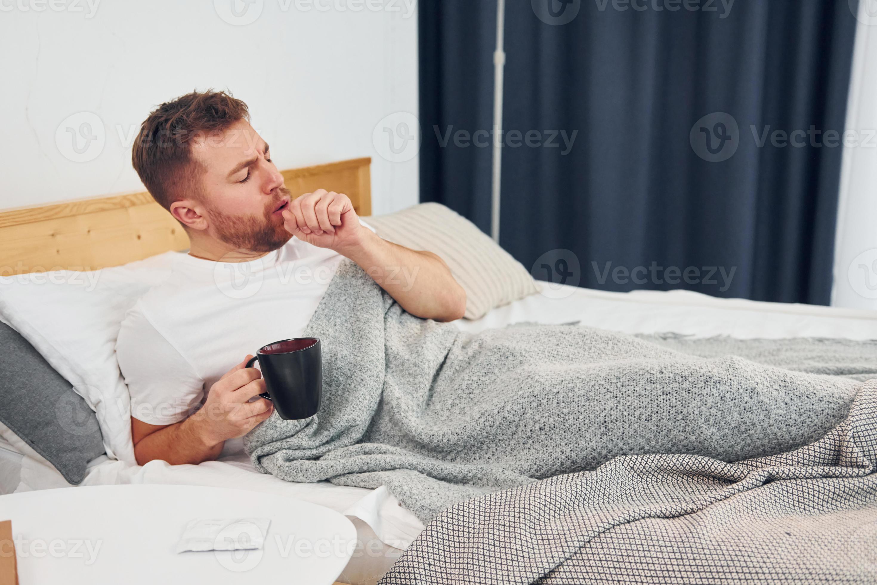 Sick man laying down on the bed at home and feels bad. Conception of