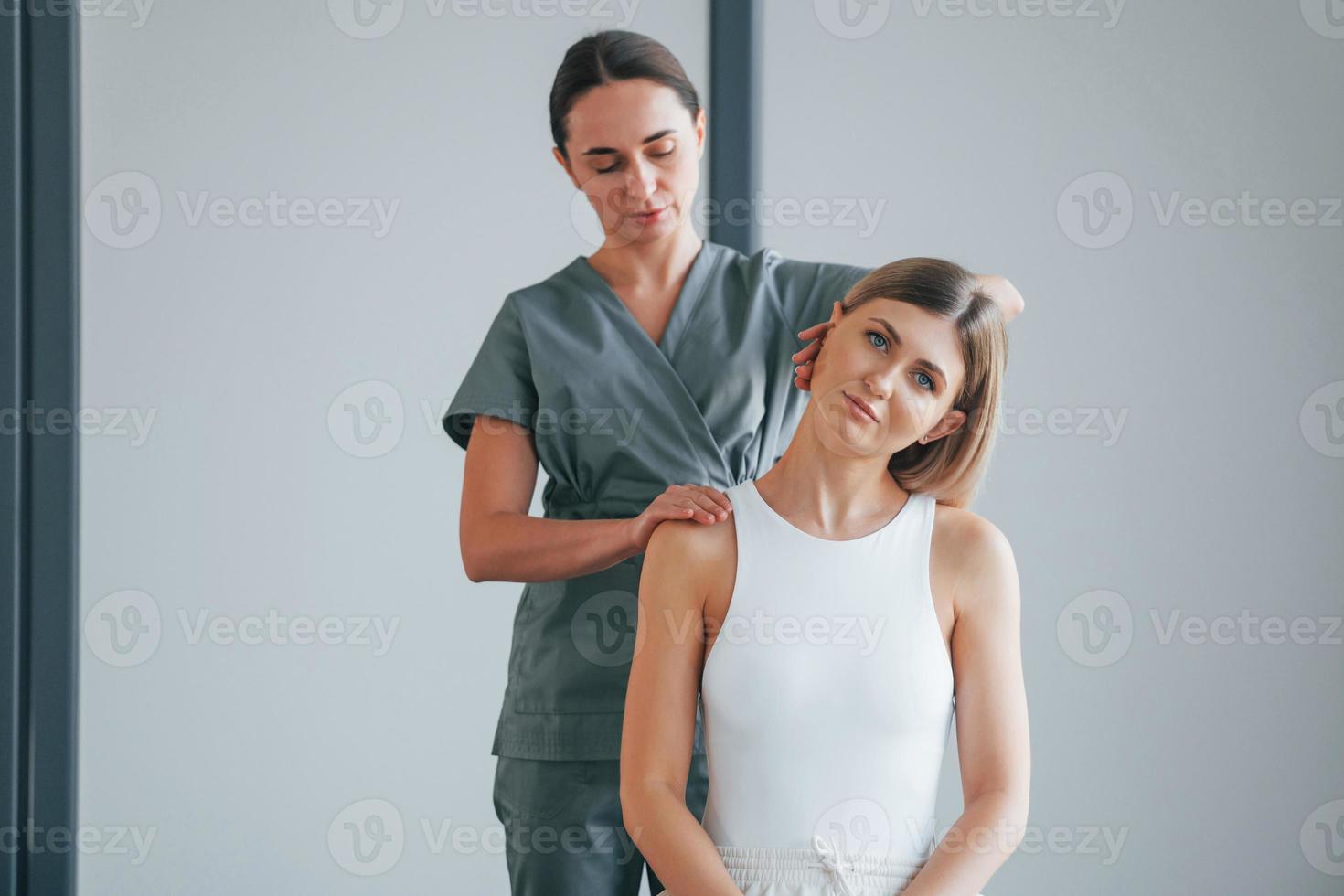 Neck exercises. Woman is in health center getting help by doctor photo