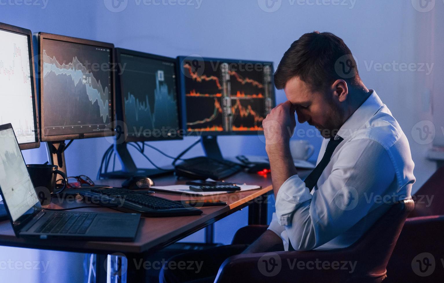 Feel bad, failure. Stock trader working in the office with exchange technology photo