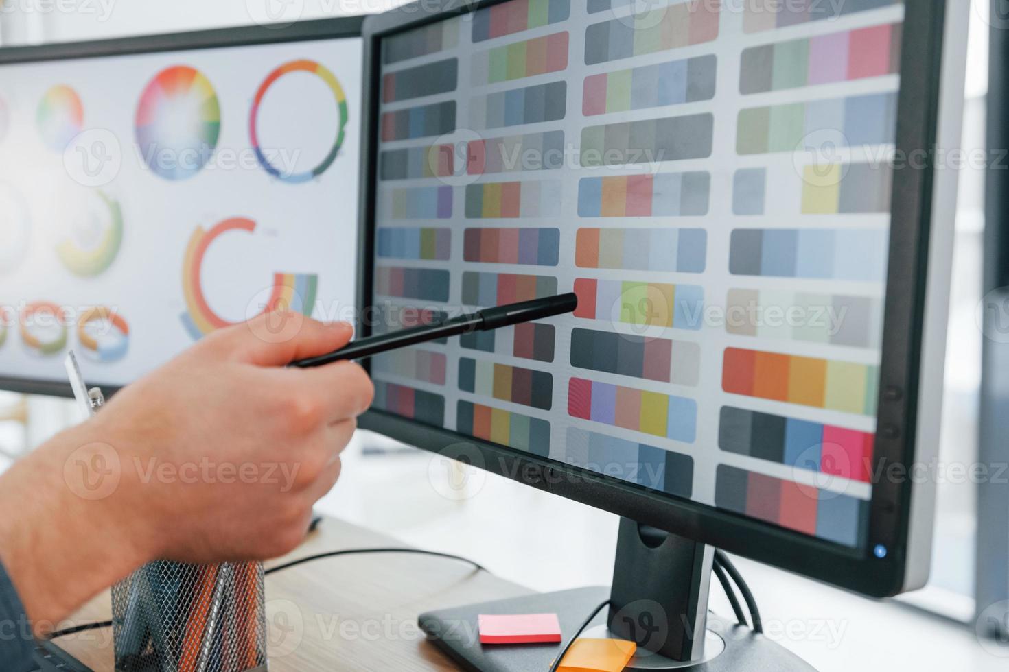 Using different colors. Male designer working in the office by using PC photo