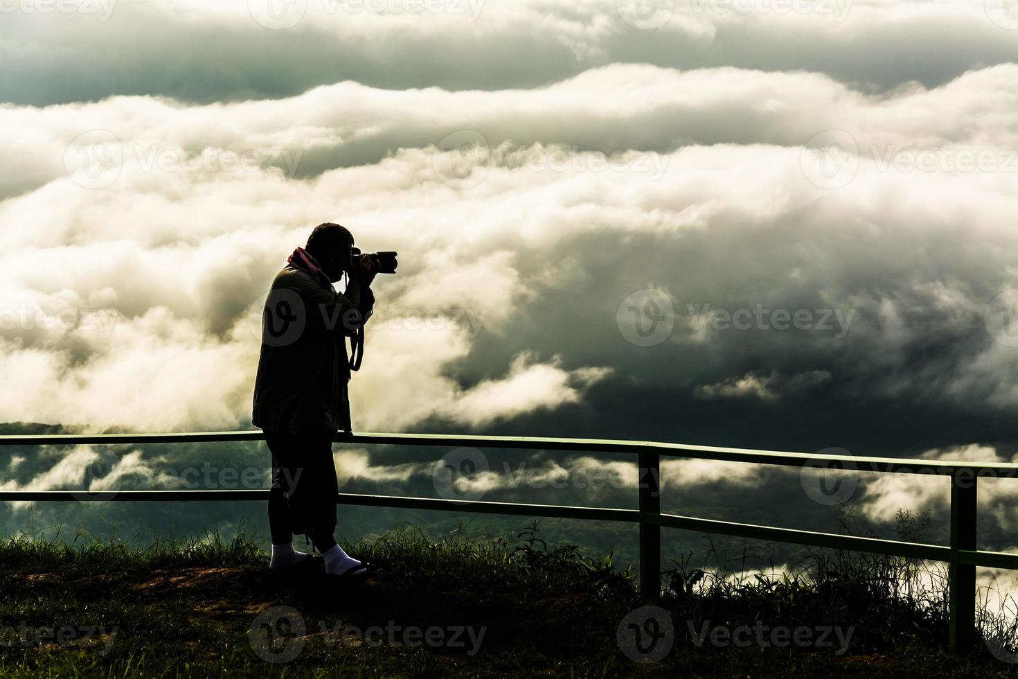 Black silhouette photographer  with  mist with Mountain ,sea of mis photo