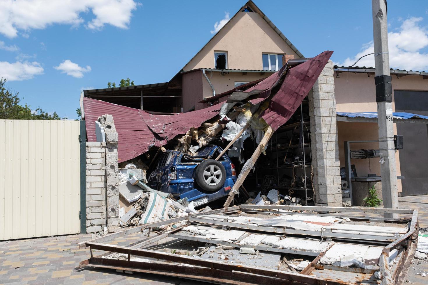 KHARKIV, UKRAINE - May, 04, 2022. Burned and broken house and car in Kharkiv countryside. War in Ukraine 2022. Russian missiles in Kharkiv Ukraine. Russian aggression. Russian attack on Ukraine. photo