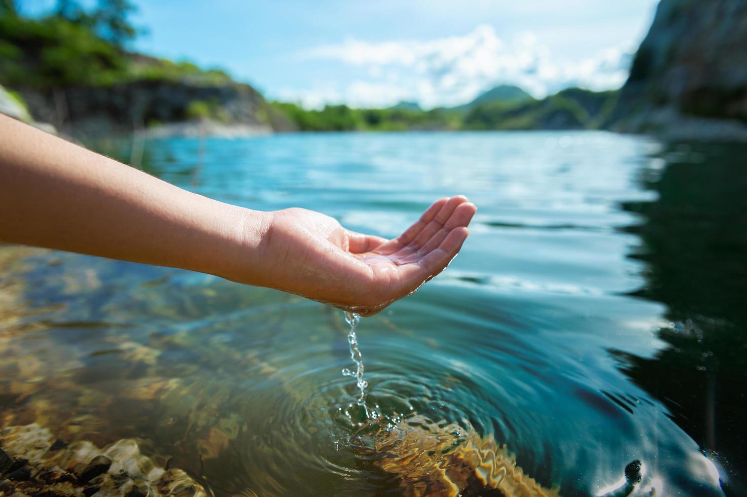 hand holding water in pond photo