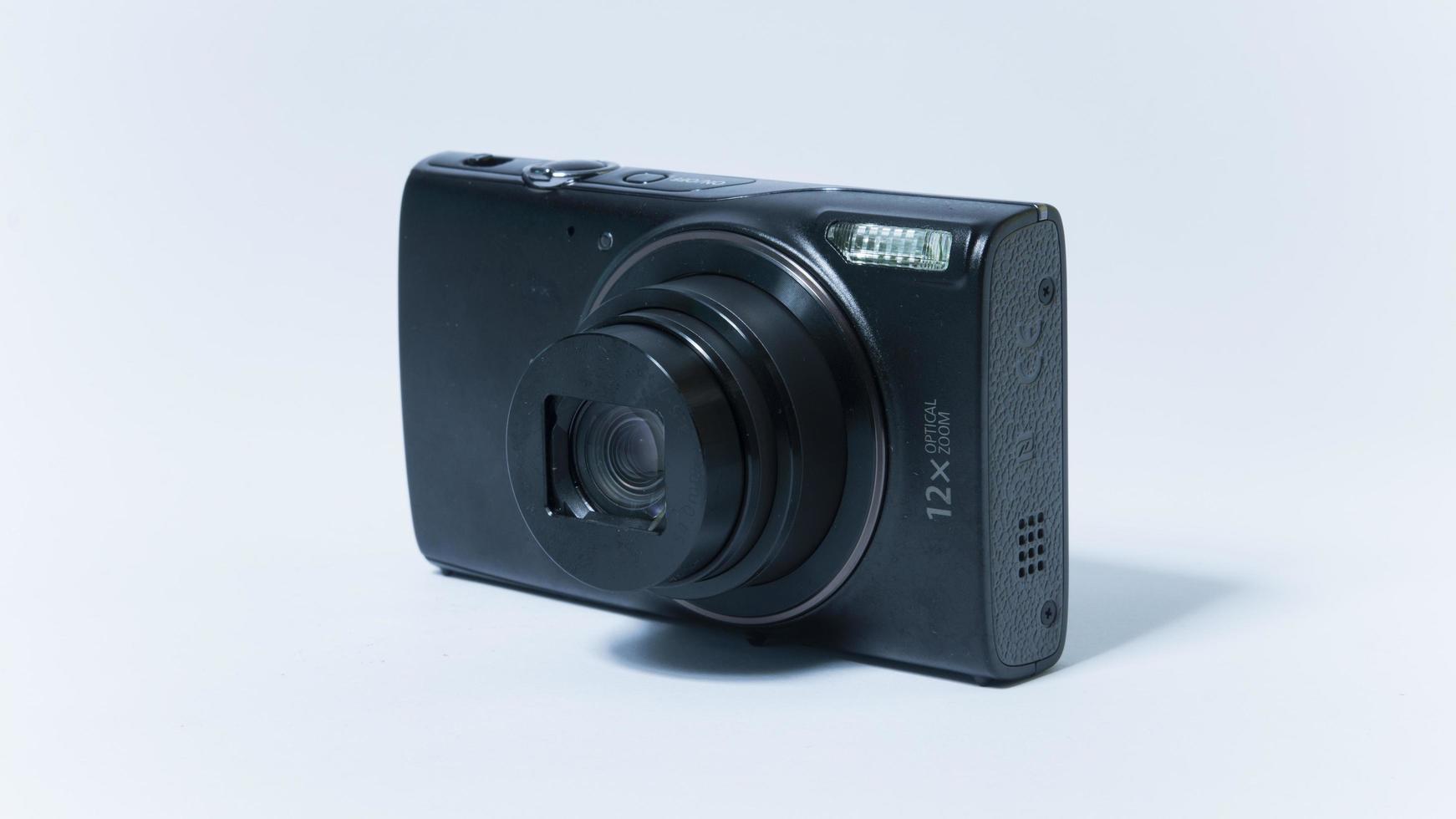 Photo of a vintage pocket camera with open lens on a white background.