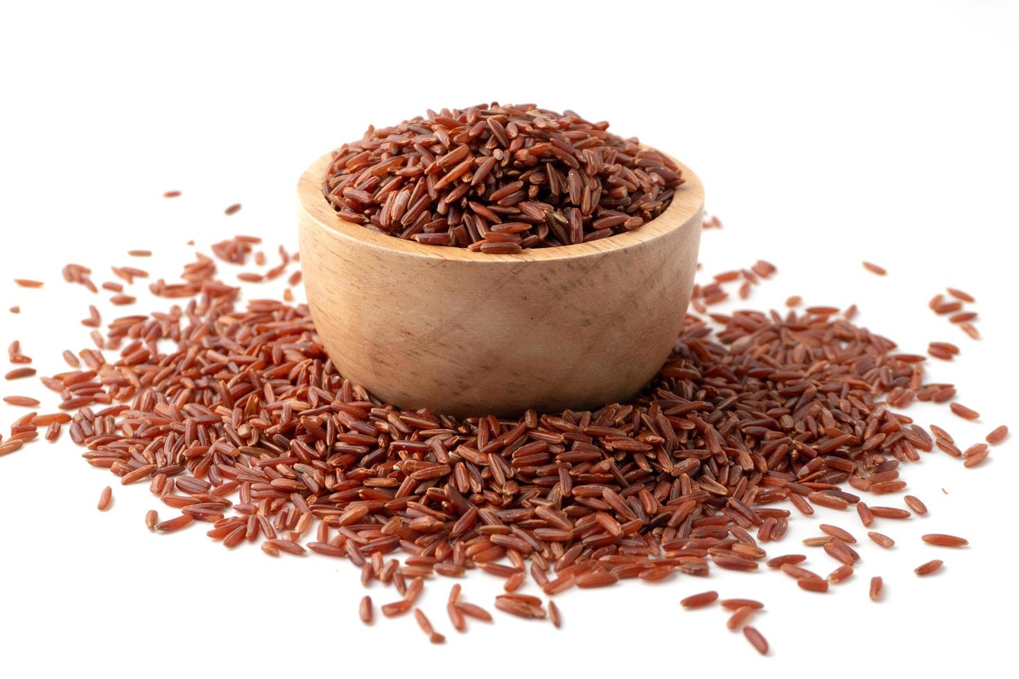 Red rice or brown rice in bowl, Red rice are scattered on the ground. photo