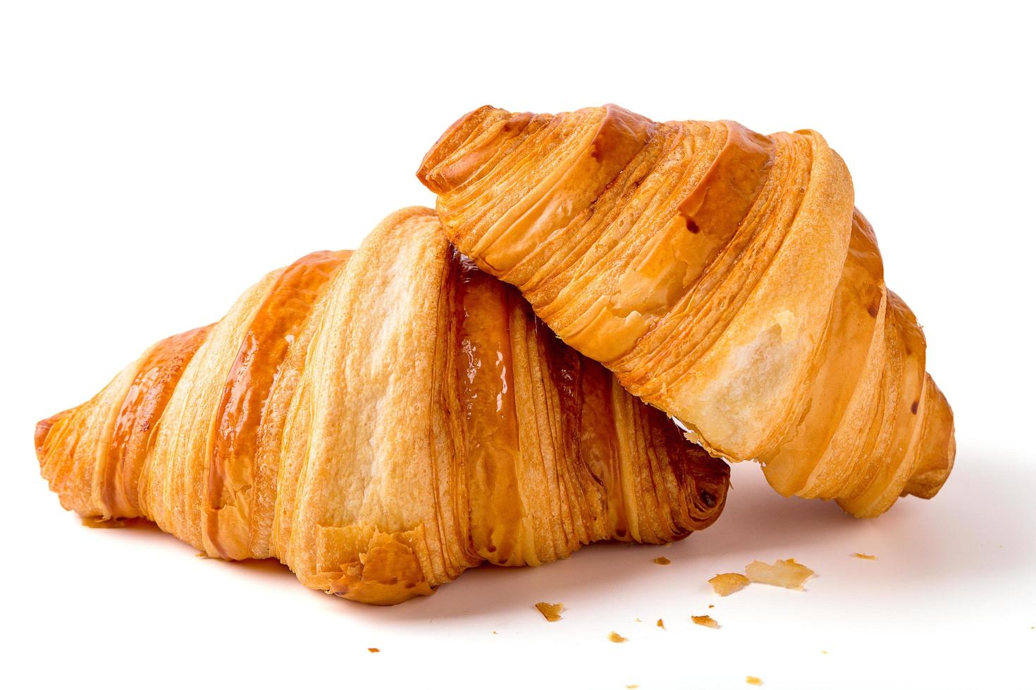 2 croissants aislados en un fondo blanco. desayuno, merienda o panadería. foto