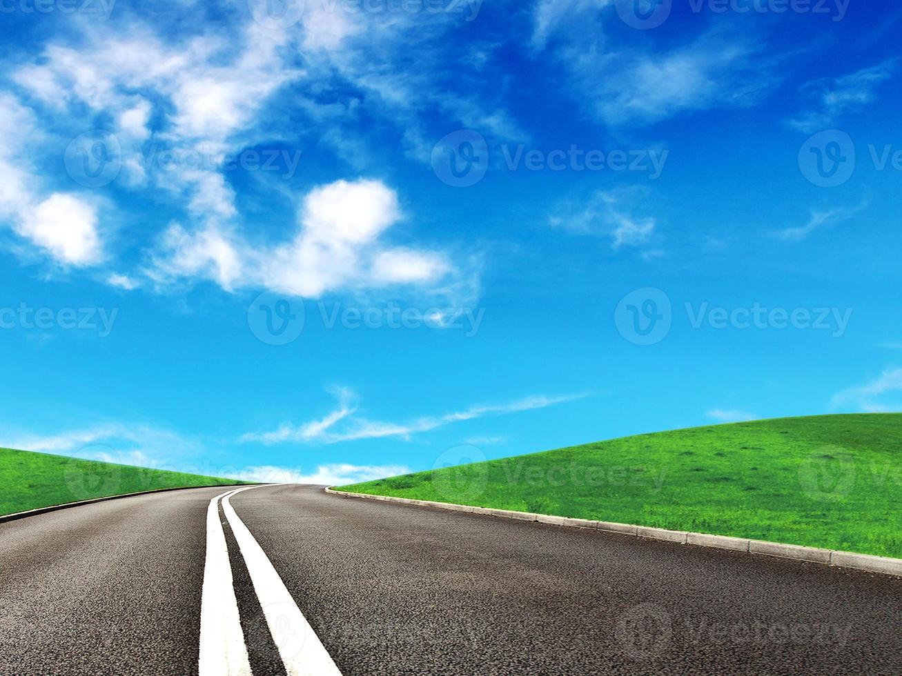 Asphalt car road and clouds on blue sky in summer day photo