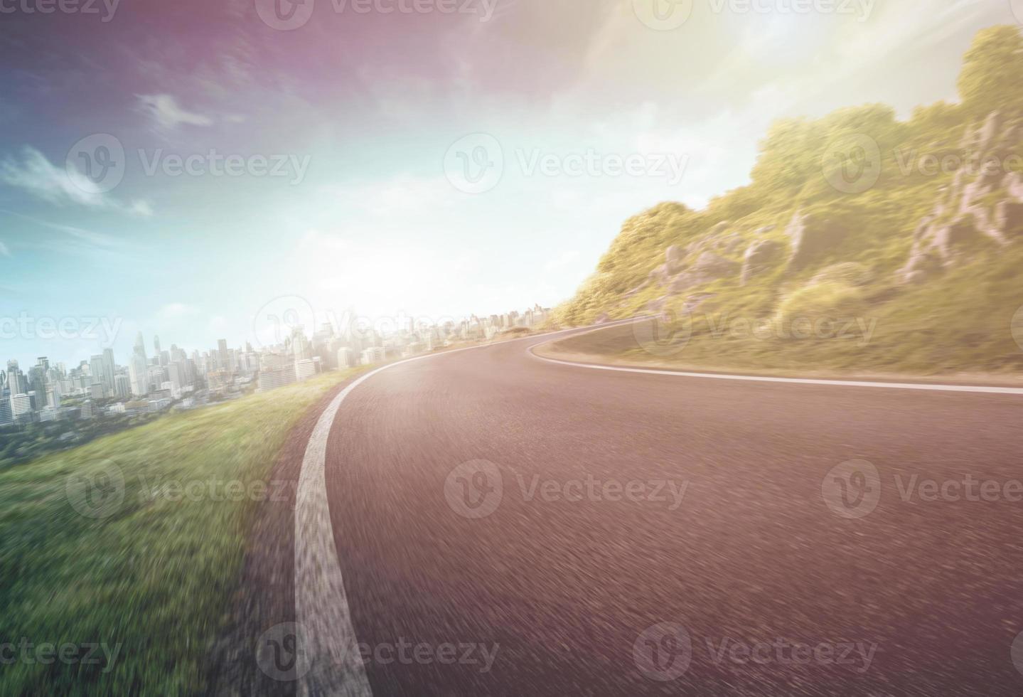 Empty long mountain road to the horizon on a sunny summer day at a bright sunset - speed motion blur effect. photo