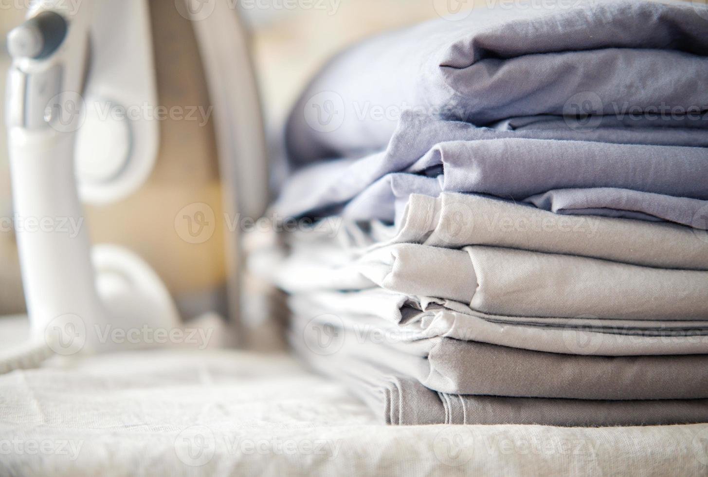 pile of bed clotheth or bed linen and iron. home work concept. photo