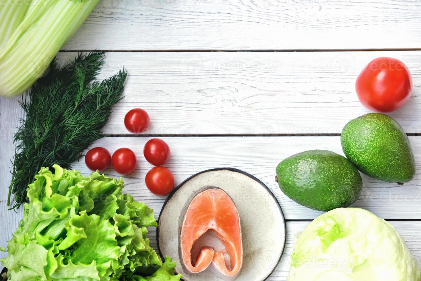 healthy meal tomatoes, fish, greens and avocado. photo