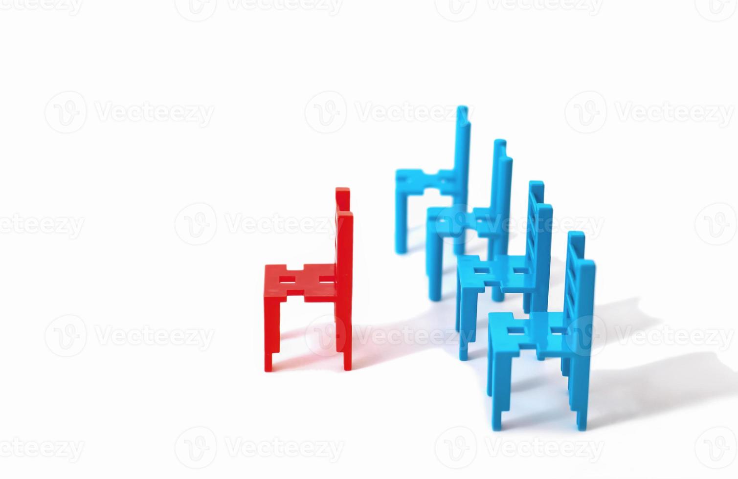 red and blue toy chairs isolated on white background. leadership concept. Standing Out From the Crowd. Asociality, sociopathy. Rejected from society, lonely. fear and misunderstanding photo