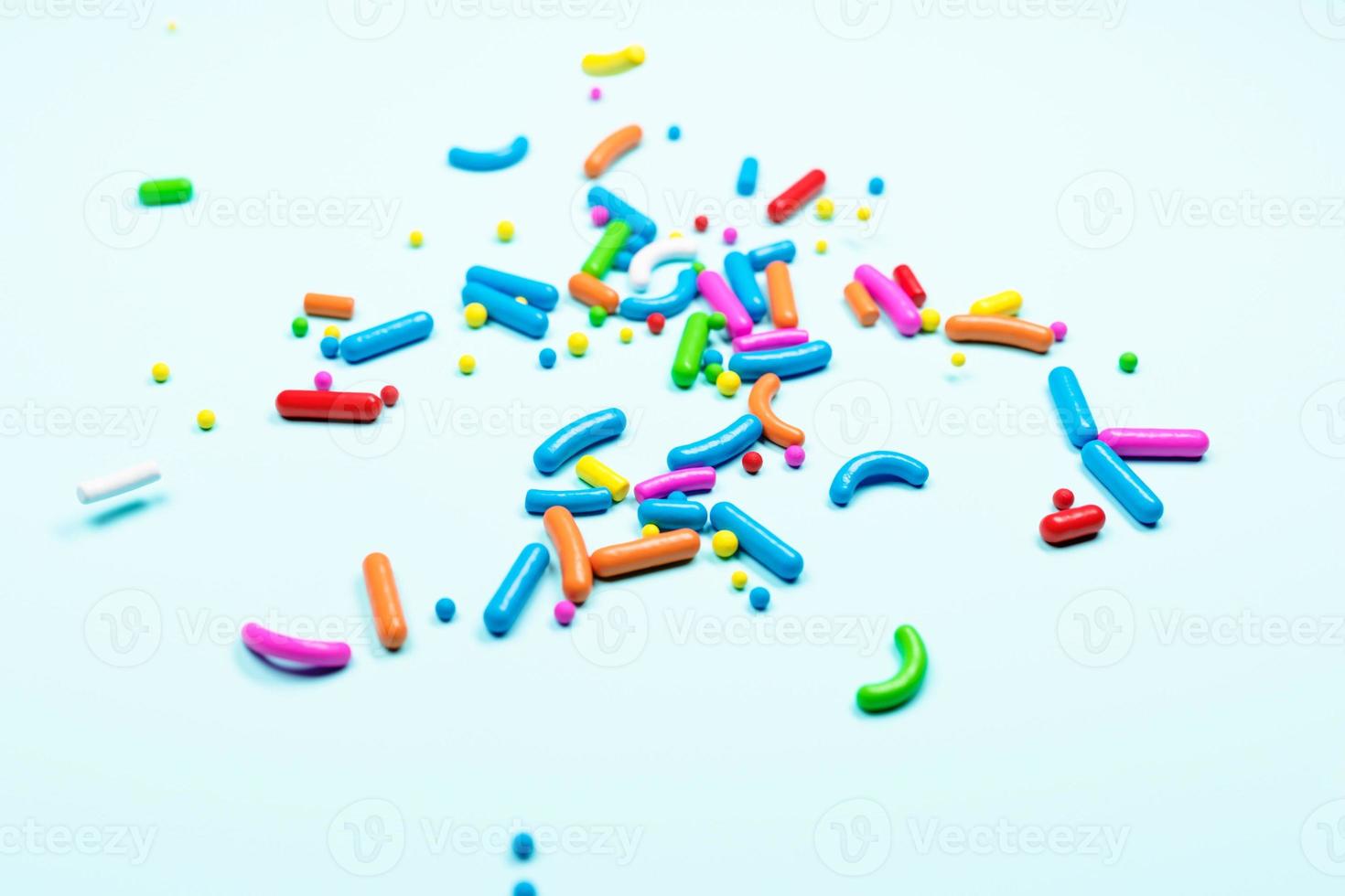 Sugar sprinkle dots colorful, decoration for cake and bakery, as a background. Isolated on blue. Easter background photo