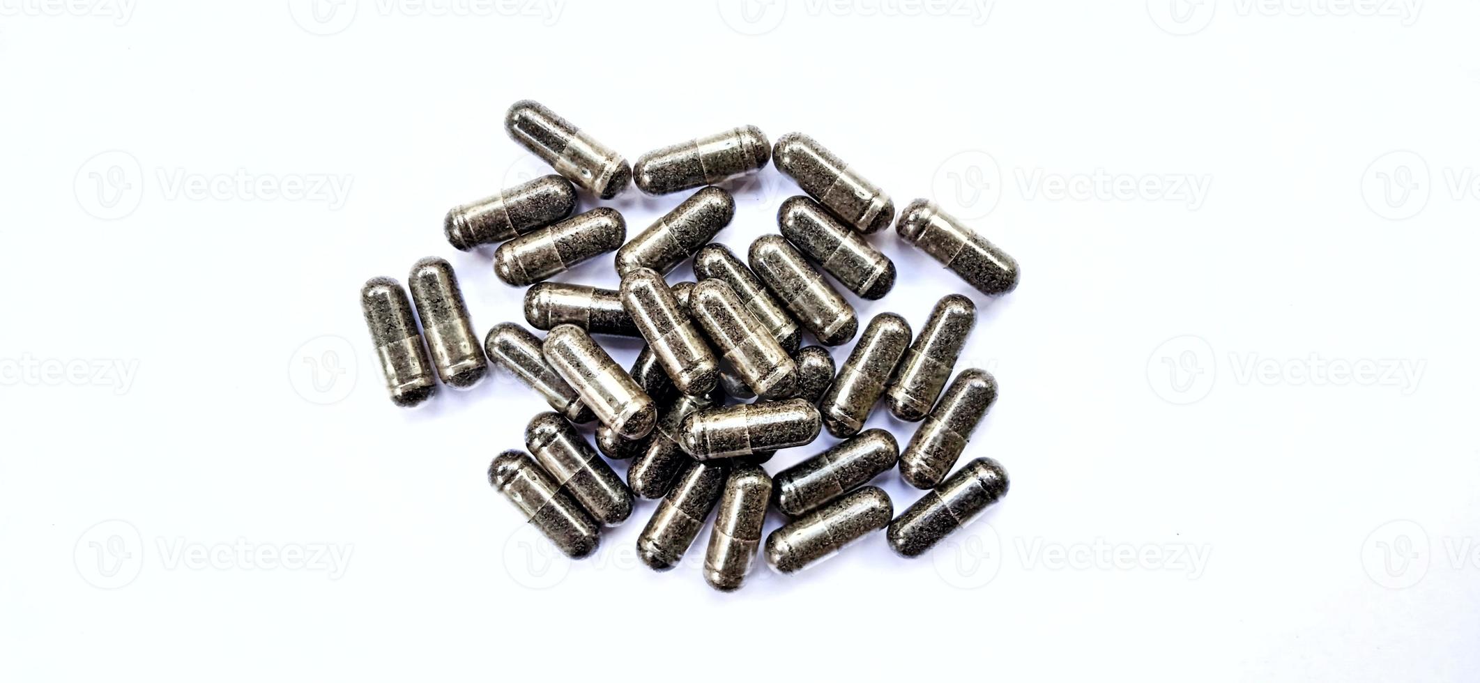 Herbal medicine black cumin capsules with negative space isolated on the gray white studio background. Nigella sativa. Suitable for promotion of health industry and company. photo