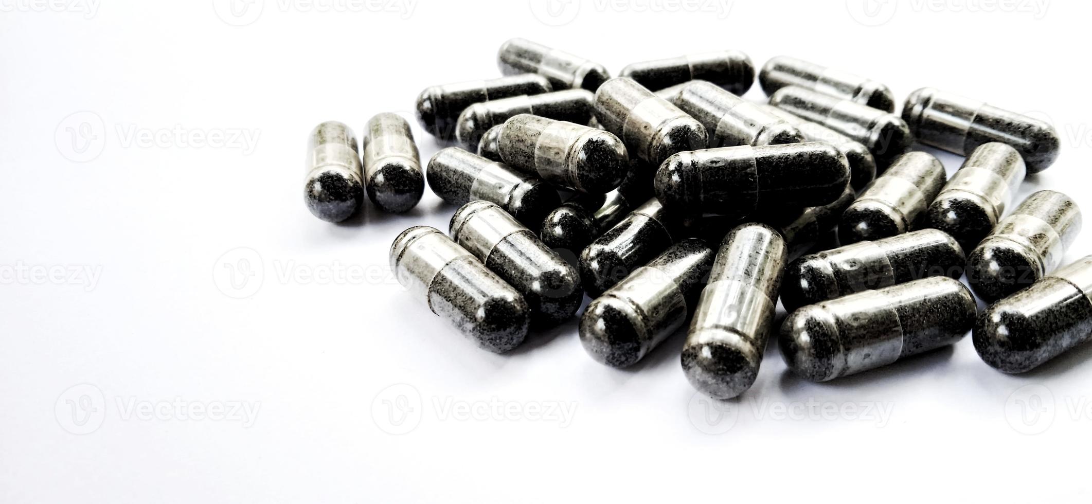 Herbal medicine black cumin capsules with negative space isolated on the gray white studio background. Nigella sativa. Suitable for promotion of health industry and company. photo