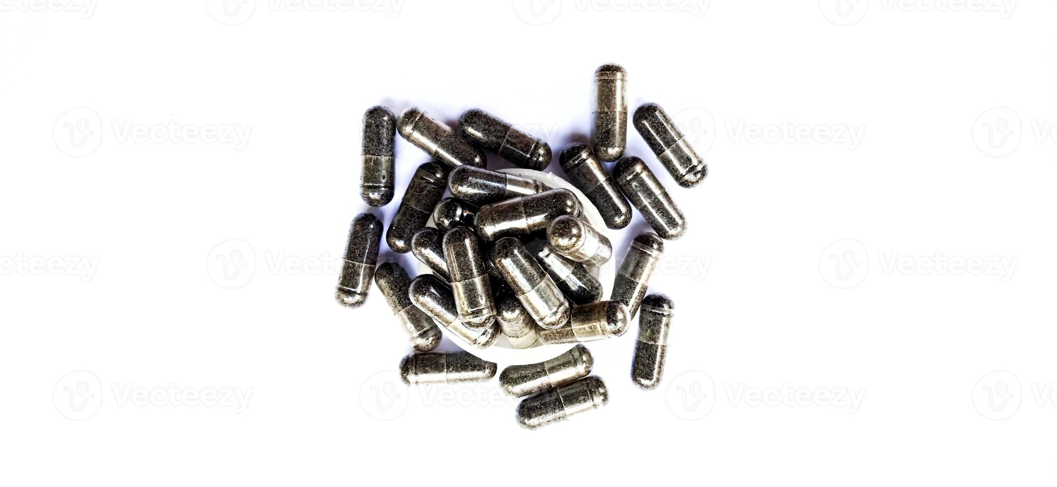 Herbal medicine black cumin capsules with negative space isolated on the gray white studio background. Nigella sativa. Suitable for promotion of health industry and company. photo