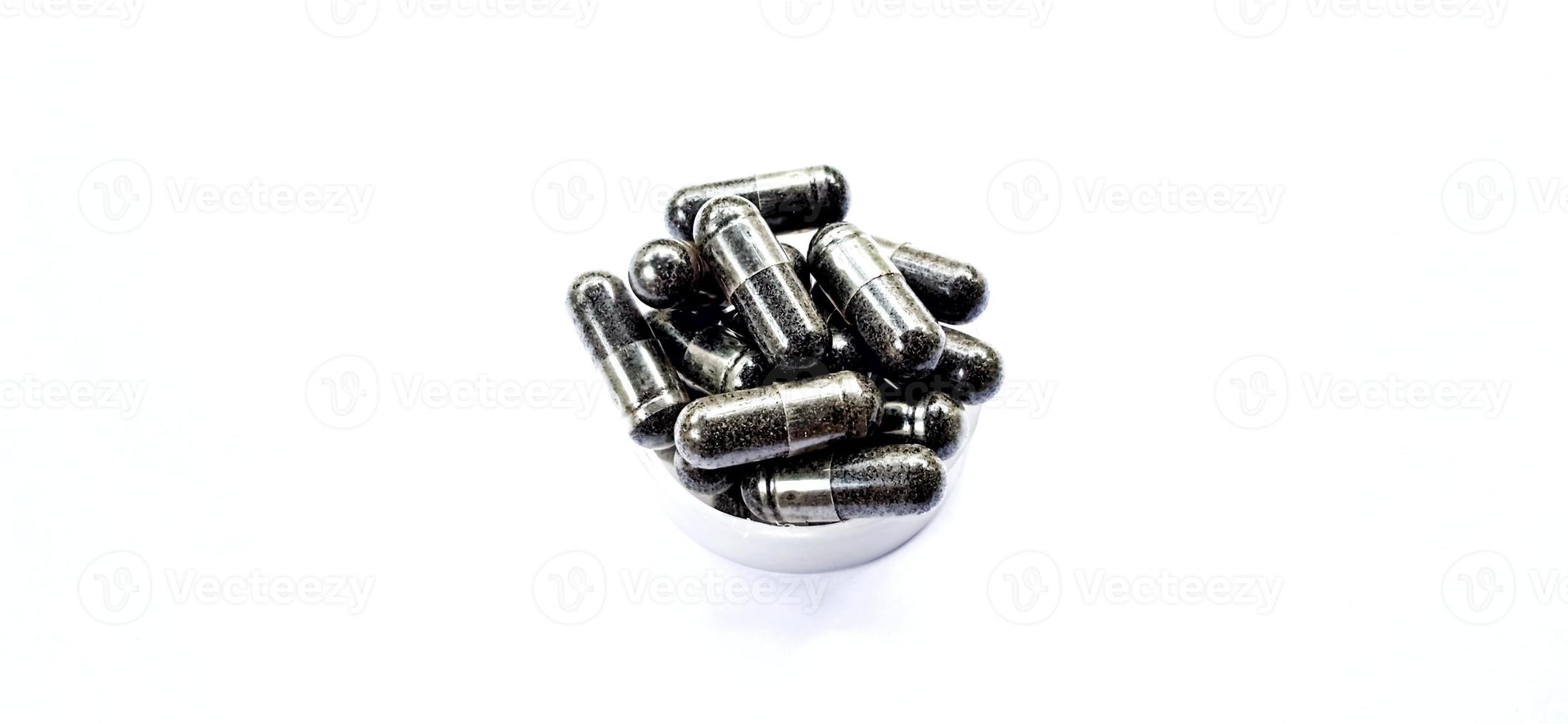 Herbal medicine black cumin capsules with negative space isolated on the gray white studio background. Nigella sativa. Suitable for promotion of health industry and company. photo